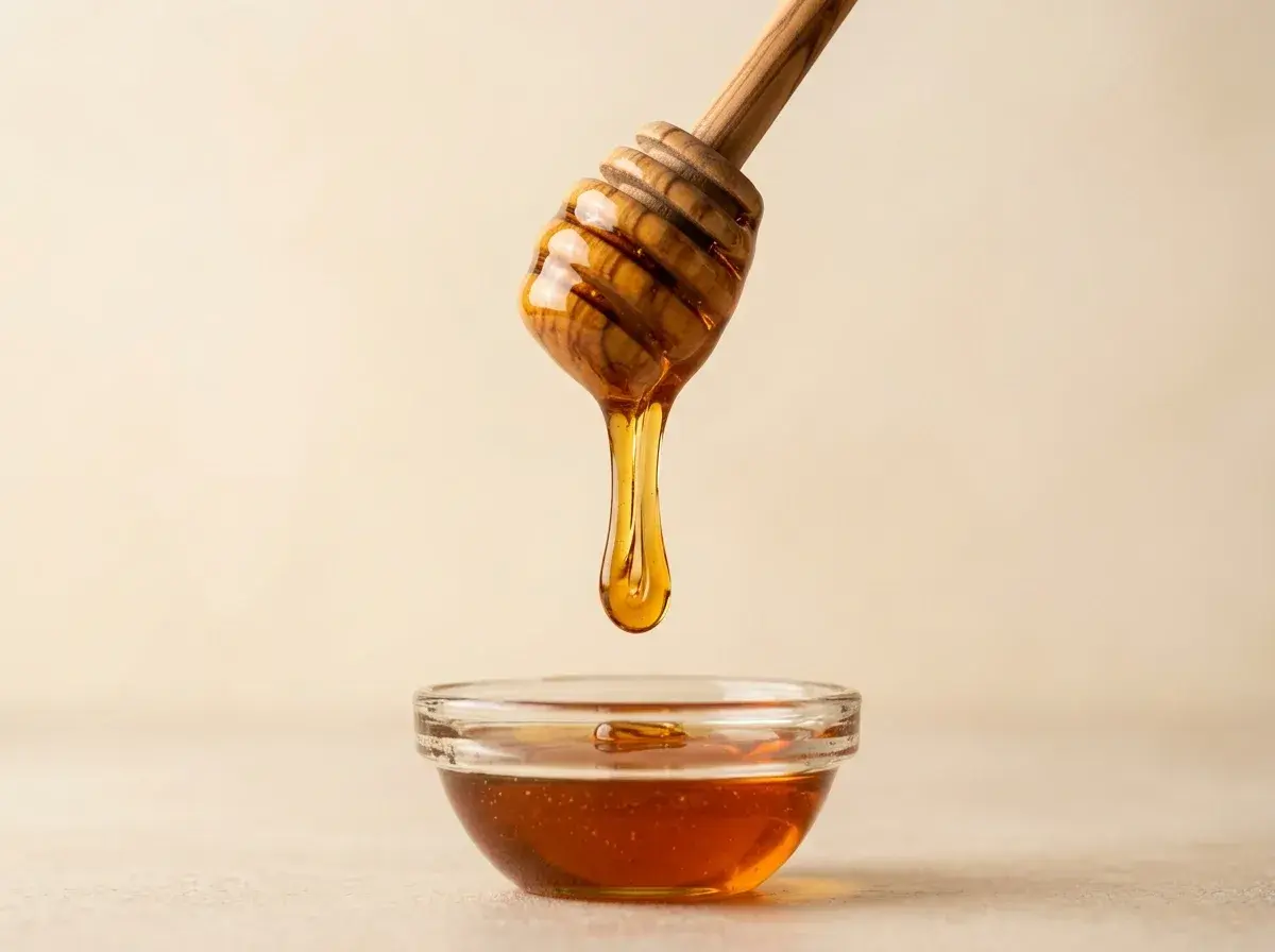 Mật ong chảy từ que gỗ xuống chén