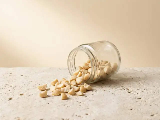 Nhân mắc ca vỡ đổ ra từ hũ thủy tinh